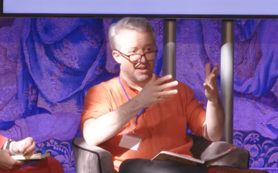 Me in an orange shirt in front of purple drapes