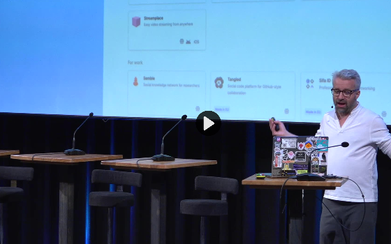 Robin Berjon mid-sentence on stage at PublicSpaces 2026.